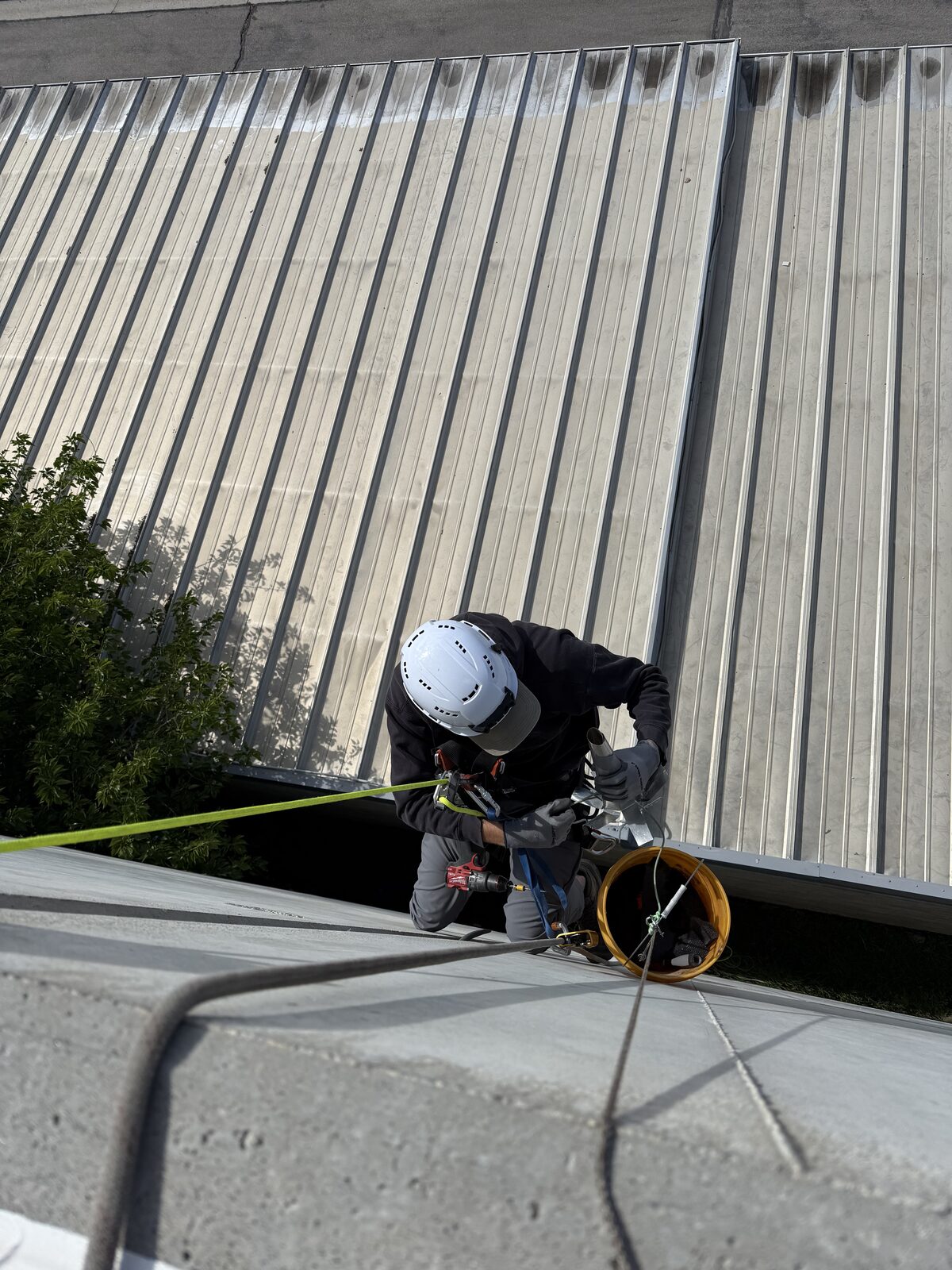 Technician repairing an upper-story exterior opening from ropes